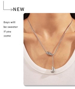 Silver snake chain necklace with dual teardrop pendants worn on a female model