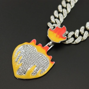 Detail of hip-hop heart flame pendant with yellow orange enamel and clear rhinestones