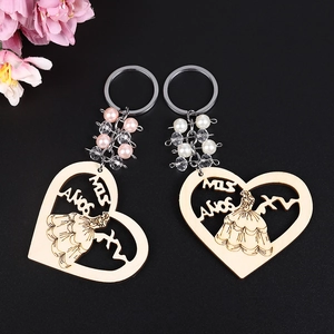 Heart-shaped wooden Mis Años keychains with elegant female carving and pearl bead charms