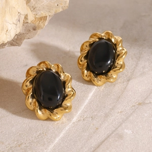 Detailed macro view of vintage gold twisted earrings with oval black stones