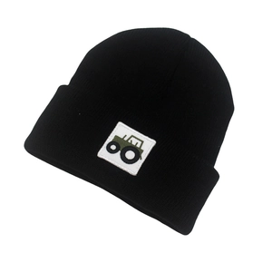 Detail showing the green tractor embroidery patch on the black ribbed knit beanie