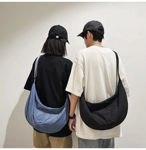 Vue de dos de modèles portant de grands sacs hobo en nylon bleus et noirs