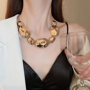 Fashionable gold necklace with irregular metallic pebble beads on an elegant female model
