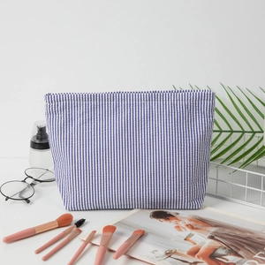 Blue and white seersucker striped makeup bag for travel storage and toiletries