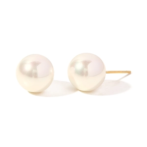 Close-up of polished white round pearls on golden metal studs with soft glowing luster