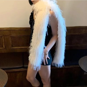 Detailed view of long white faux fur shawl styled over a black evening dress