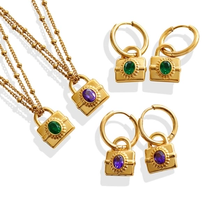 Gold padlock jewelry set featuring green and purple oval gems on layered bead necklaces