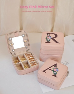 Pink PU leather travel jewelry box with floral initials, mirror, and zipper closure