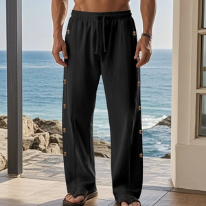 Detail of black linen trousers with drawstring waist and decorative buttons on the side