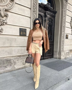 Detail of premium brown PU leather blazer paired with a beige knit crop top and shorts