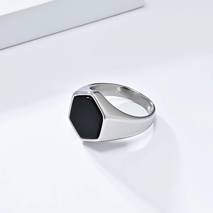 Minimalist silver steel ring with a hexagonal black stone on white geometric stands