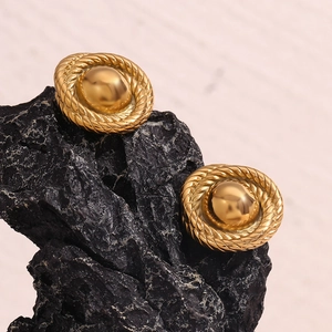 Macro detail of gold-plated twisted rope textured button earrings on black stone