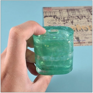 Close-up of translucent green resin earphone case with shimmering glitter and sequins