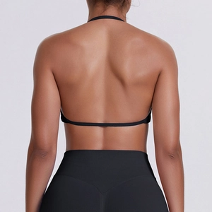 Detail of a seamless black halter-neck sports bra with a low back design and matte finish