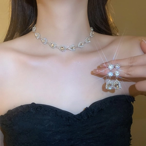 Close-up of sparkling waterdrop rhinestone necklace and drop earrings set on a model