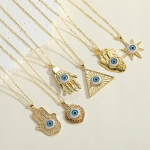 Macro shot of assorted gold evil eye pendants with blue eye details on stone background