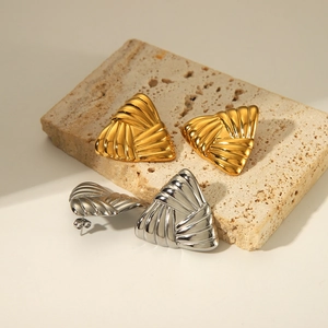 Detailansicht dreieckiger gestreifter Ohrringe in Gold und Silber mit Faltentextur