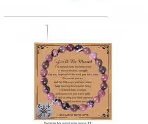 Detail view of 8mm natural stone beaded bracelet with compass charm on sentiment card