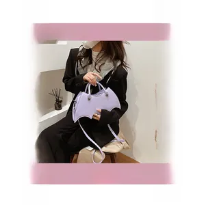 Detail view of lilac PU leather bat-shaped handbag with spider web quilting and silver hardware