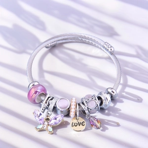 Detail view of silver charm bracelet with purple glass beads and butterfly pendant