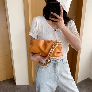 Chic orange cloud bag with chunky gold chain strap and soft pleated vegan leather detail