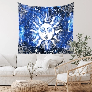 Detail of bohemian tapestry featuring sun and moon patterns over a minimalist white sofa