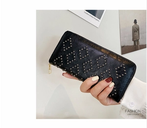 Detailansicht der schwarzen Leder-Clutch mit silbernen Nieten und goldenem Reißverschluss