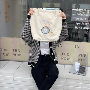 Détail du sac cabas en velours côtelé avec broderie et fermeture à bouton en bois