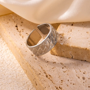 Detailed view of silver stainless steel wide ring featuring geometric diamond pattern textures