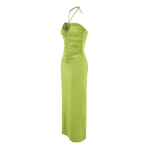 Close-up of green halter maxi dress featuring side ruching and a 3D fabric rose detail
