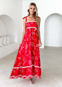 Detail view of a red floral maxi dress featuring white wavy edges and Ciao print