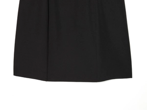 Détail de l'ourlet d'une robe noire montrant des coutures et un tissu de qualité