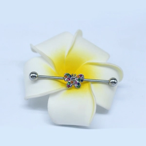 Detailed view of silver butterfly industrial barbell with colorful crystals on a flower