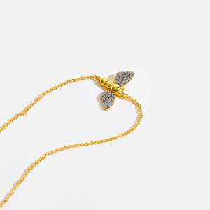 Macro shot of gold bee pendant with sparkling cubic zirconia on a delicate chain
