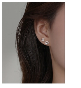Macro shot of asymmetrical silver S925 star and moon stud earrings with zircon stones