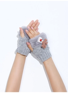 Dettaglio di guanti senza dita grigi in maglia con renna di peluche e bordo in pelliccia
