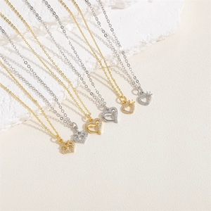 Detail of heart, crown, and star pendants in gold and silver with cubic zirconia inlays