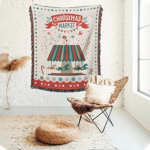 Detail of Christmas market woven throw blanket with festive tassels and carousel design