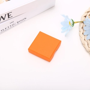 Close-up of a square orange jewelry gift box with textured orange peel finish for necklaces