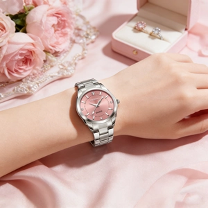 Close-up of women's quartz watch with pink dial and silver band on a floral background