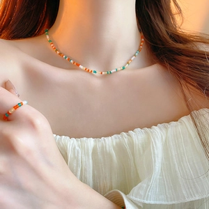 Close-up of vibrant multi-color beaded necklace and matching ring set for summer outfits