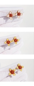Detailed close-up of enamel flower earrings in white and yellow petals with red center