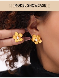 Gros plan détaillé de boucles d'oreilles pétales dorés avec perle sur un mannequin