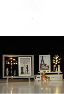 Gros plan du cadre photo en bois rotatif avec lumière LED chaude et figurines de conte