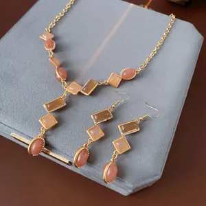 Vintage gold jewelry set with peach crystals and rhinestone tassels in square and oval shapes