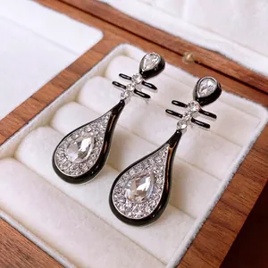 Modern Pipa-shaped silver drop earrings with black enamel and glistening cubic zirconia