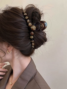Dettaglio del fermaglio per capelli con perle ambrate per un'acconciatura elegante