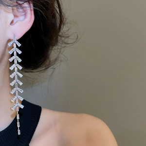 Détail de boucles d'oreilles pendantes en argent avec zircons et pampilles