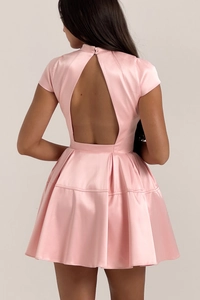 Dettaglio mini abito in raso rosa con elegante taglio senza schienale e gonna a pieghe
