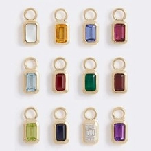 Macro display of twelve colorful rectangular gemstone pendants with gold plated settings